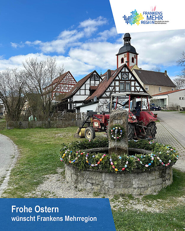 Ostern in Frankens Mehrregion Osterbrunnen vor einem Kirchturm und Fachwerkhäusern